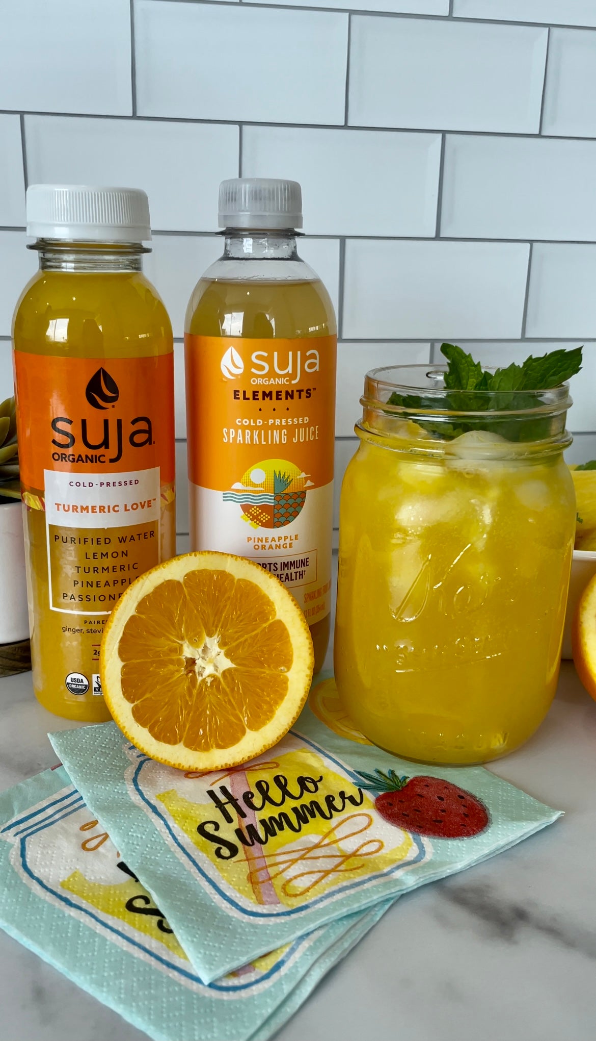 Summer Spritzer on counter with orange and Suja bottles