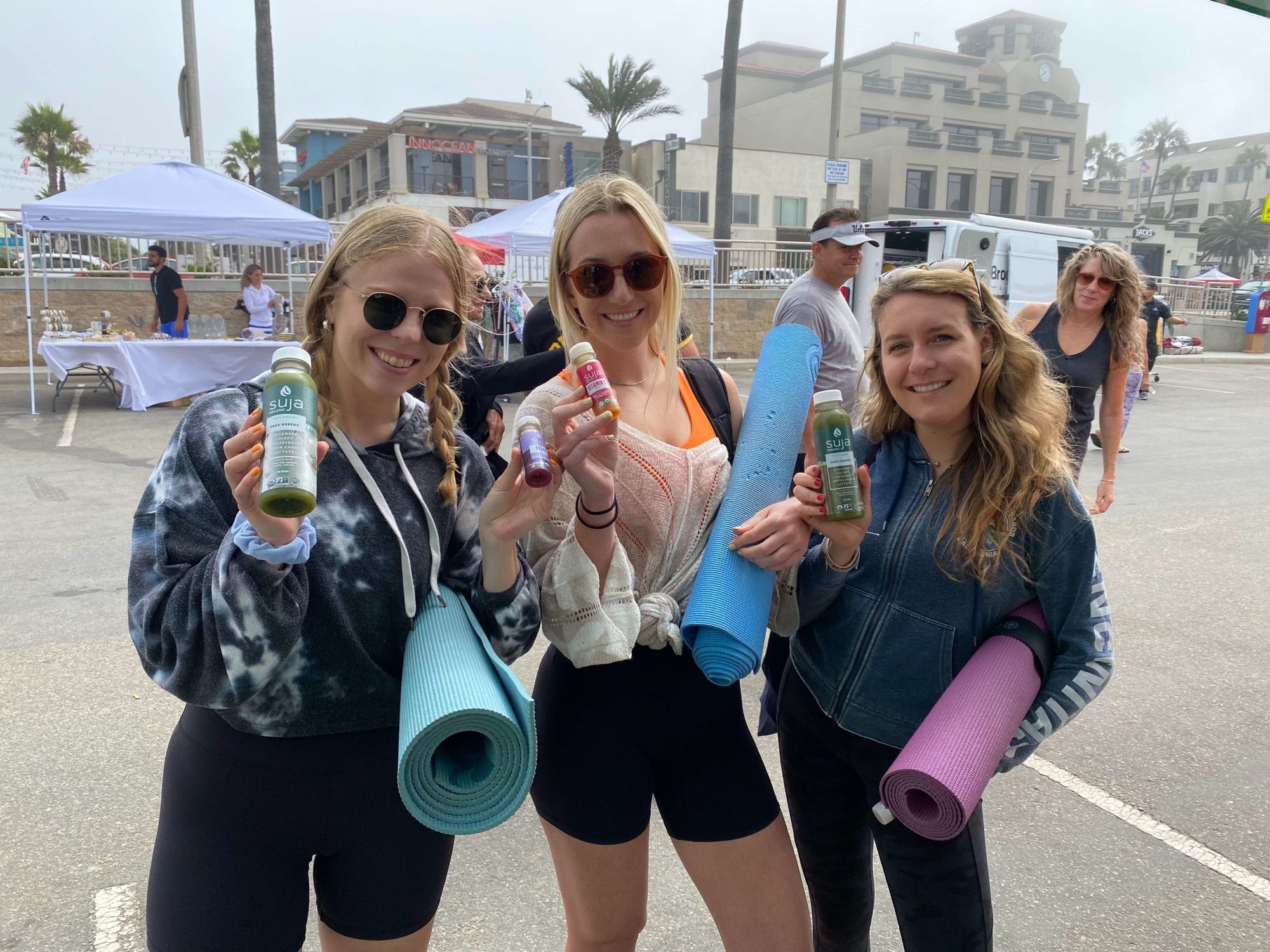 Girls holding Suja and yoga mats