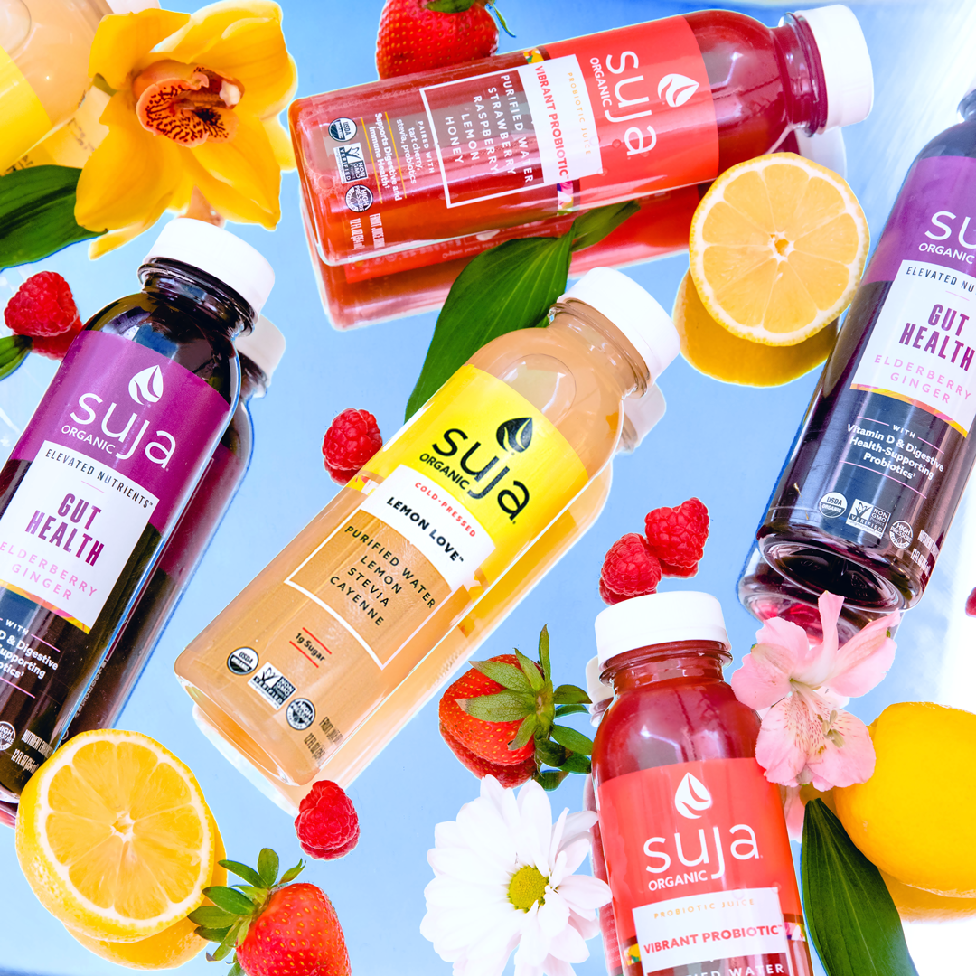 Suja bottles with fresh fruit in spring sky